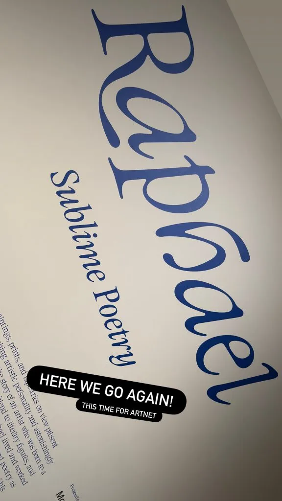 Exhibition title wall displaying "Raphael: Sublime Poetry" in large blue lettering on a white background, with partial wall text visible describing the artist