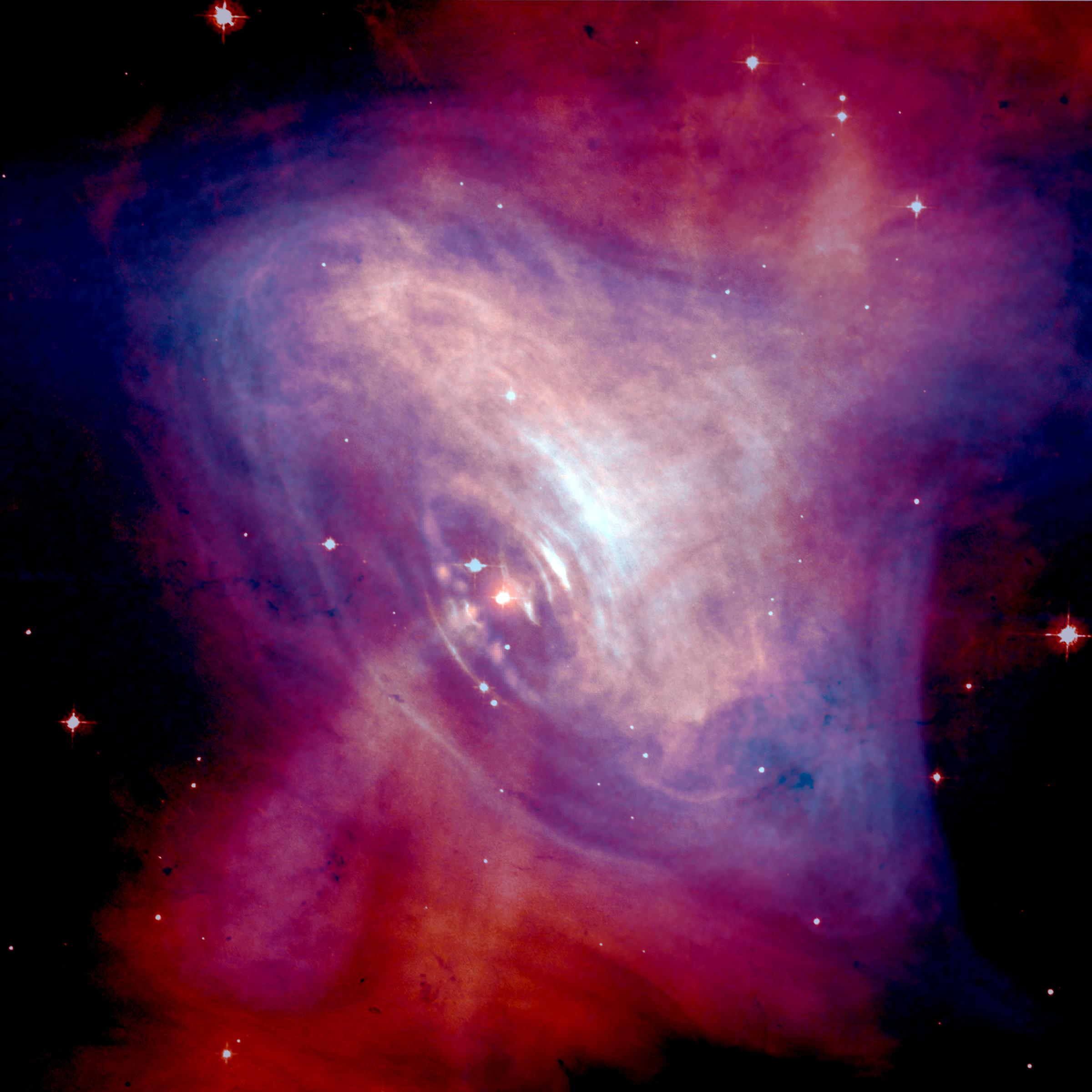 A composite image of the Crab Nebula showing the X-ray (blue), and optical (red) images superimpo...