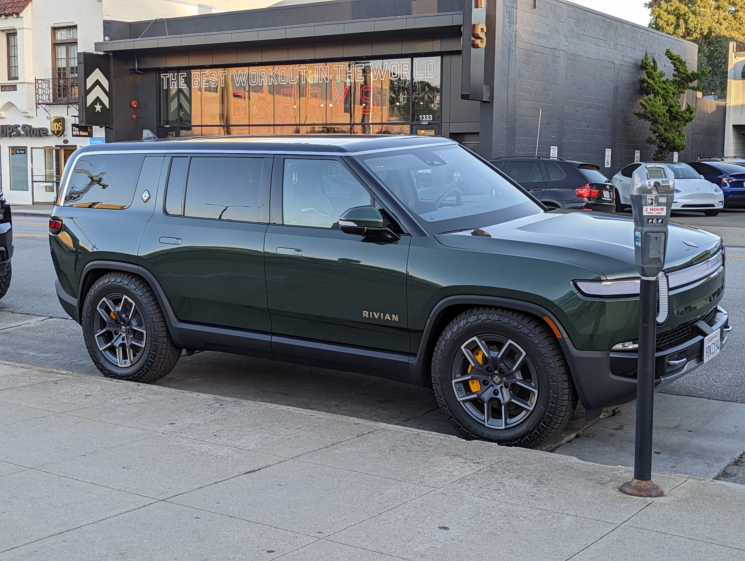 Rivian R1S sport utility vehicle in a dark green color, parked on Howard Avenue in Burlingame Cal...