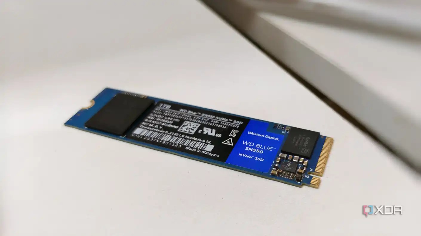 A blue SSD without a heatsink placed on a white desk