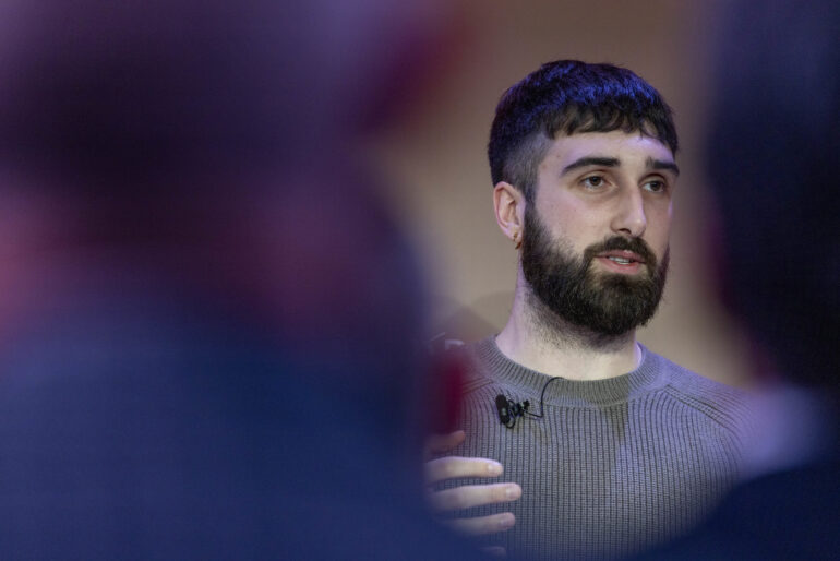 portrait of aidan gomez speaking at event