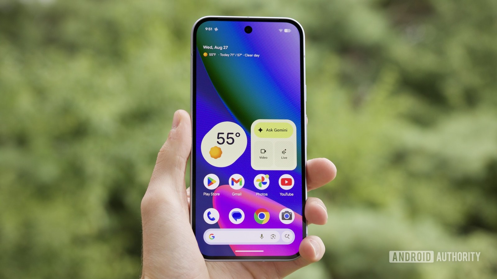 Someone holding the Google Pixel 10 with its screen on, showing the home screen.