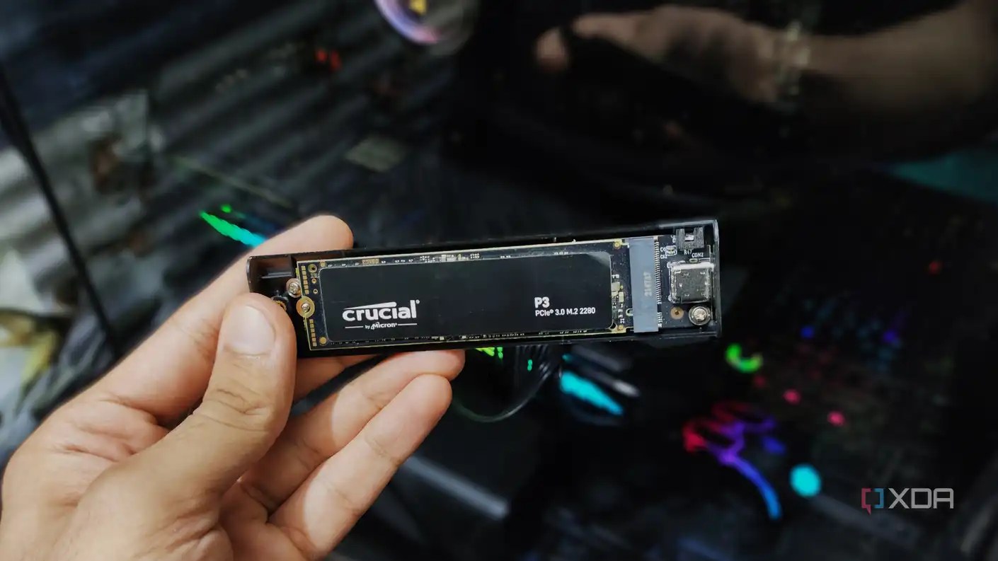 A hand holding an NVMe enclosure.