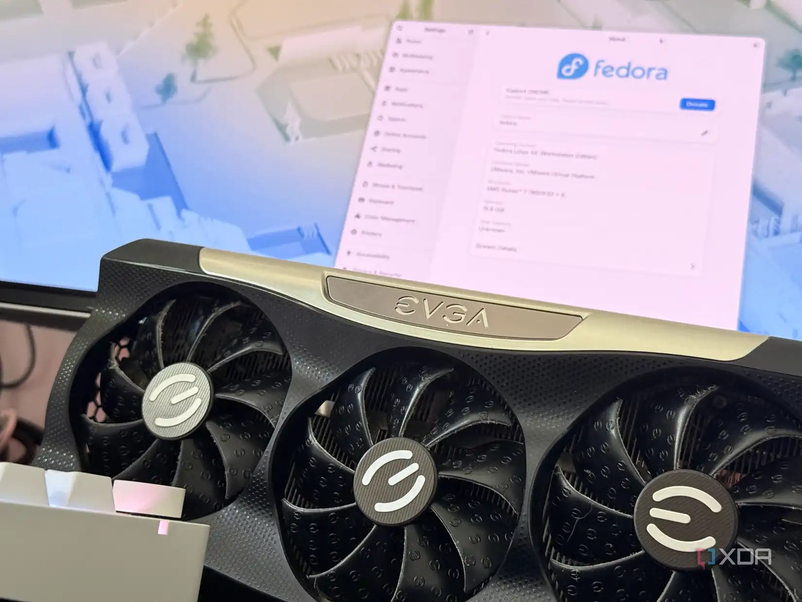 A graphics card on a desk in front of a Fedora Workstation system
