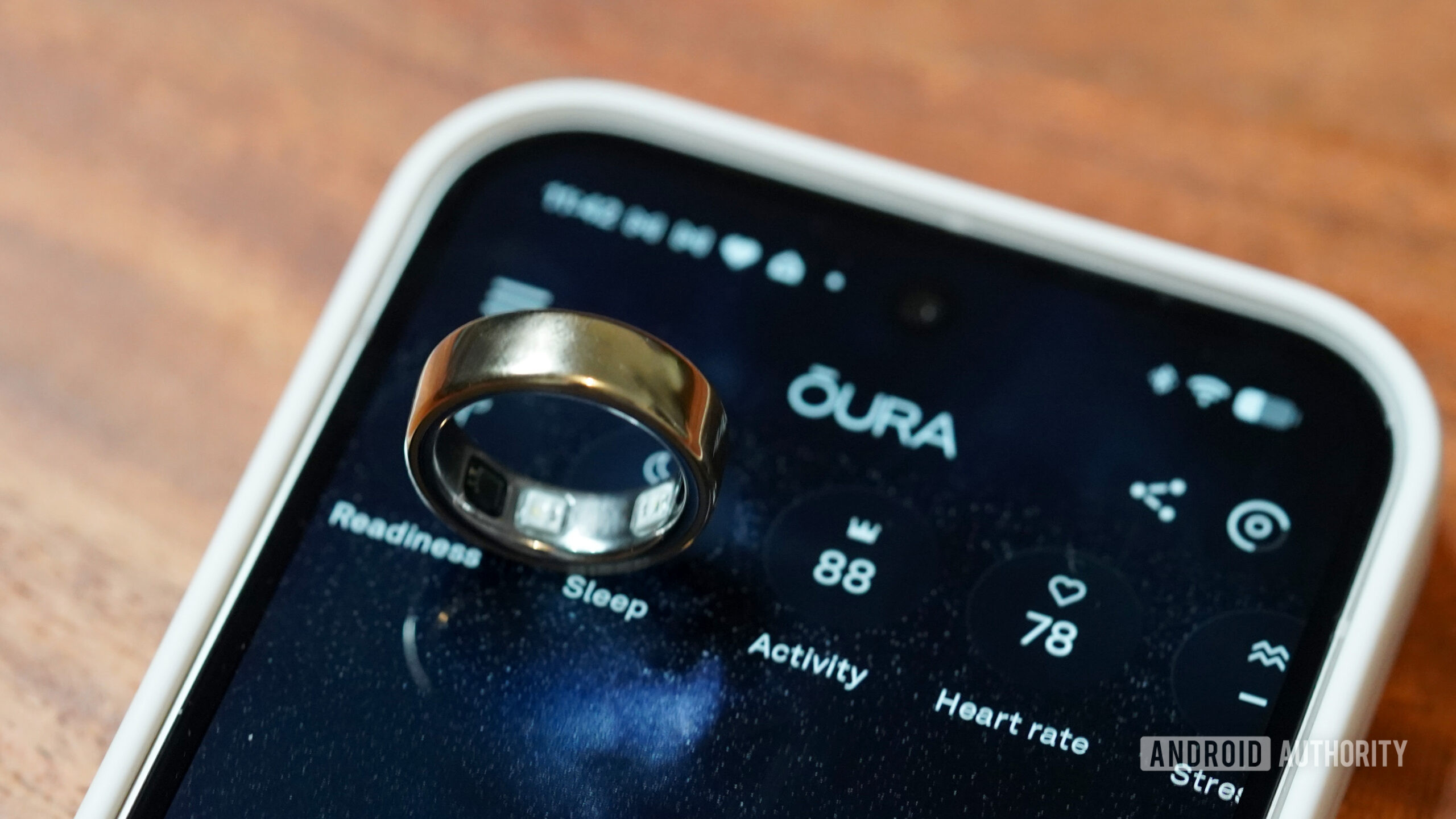 An Oura Ring 5 balances on a phone displaying the Oura app.