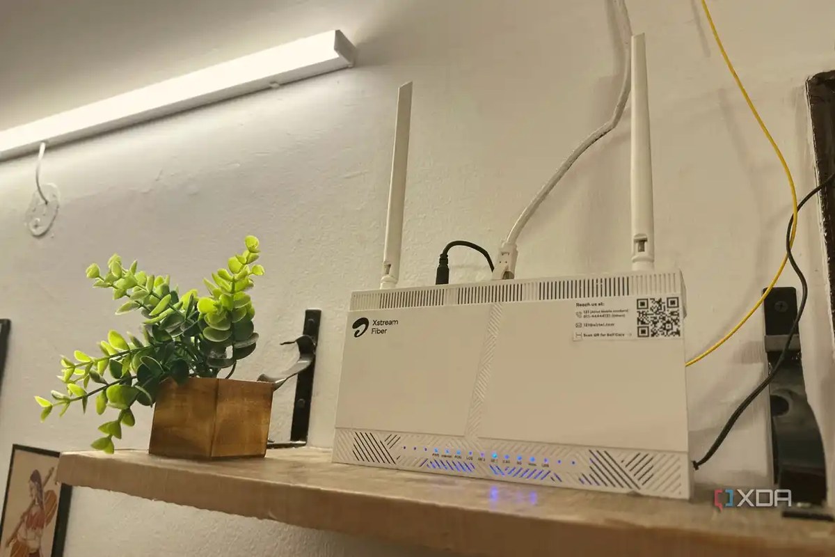 Wi-Fi router on top of a wall-mounted wooden shelf.