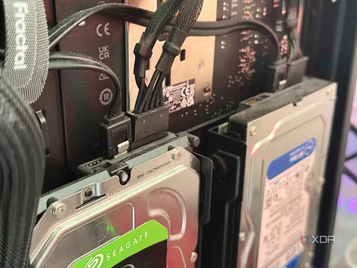 A photo of two hard drives installed behind a PC's motherboard tray