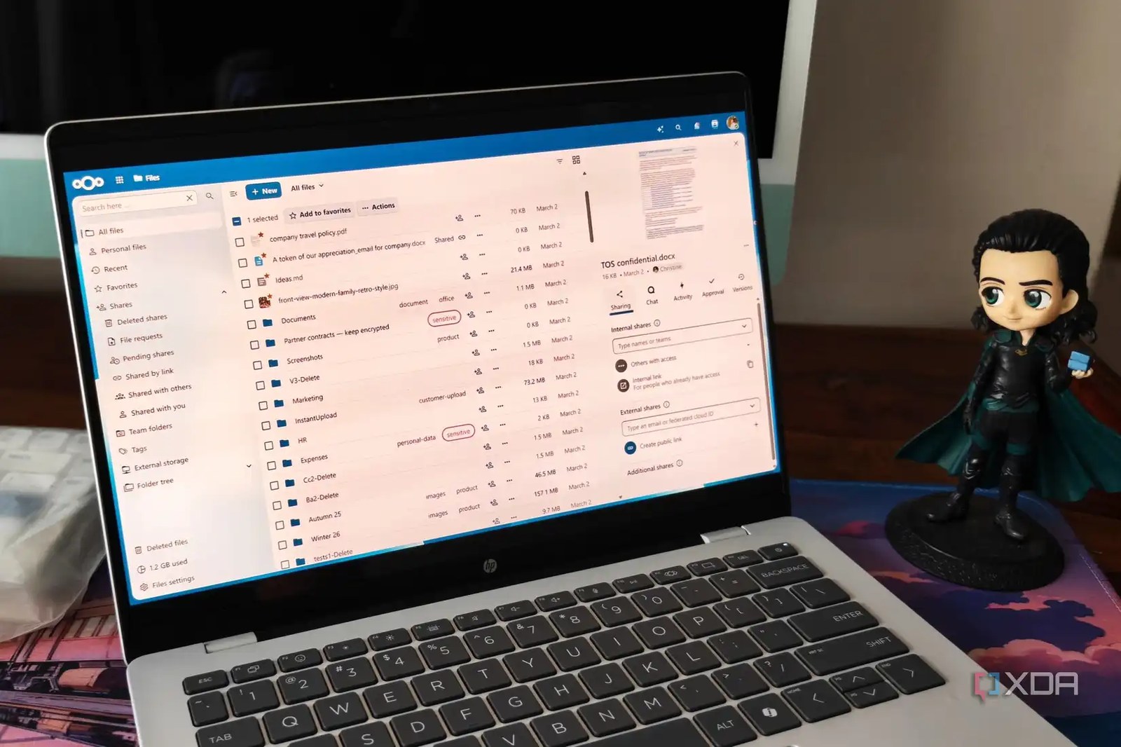 Nextcloud screen on a laptop on a brown desk next to a figurine