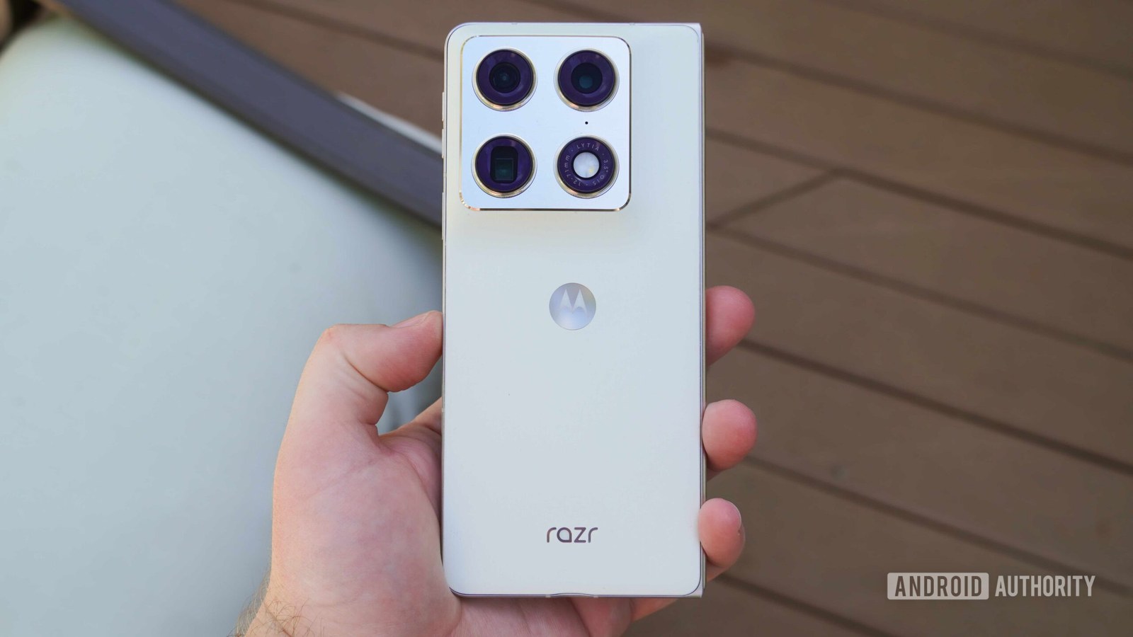 The Razr Fold in Lily White held in the hand.