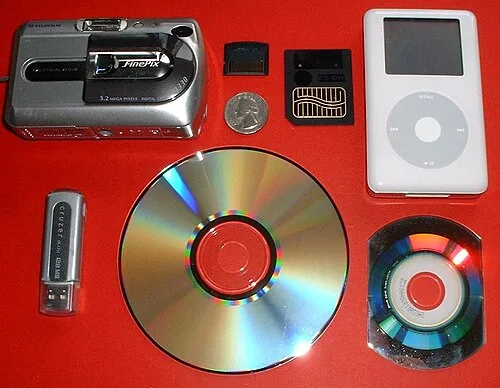 Various electronic storage devices and media, with a coin for scale