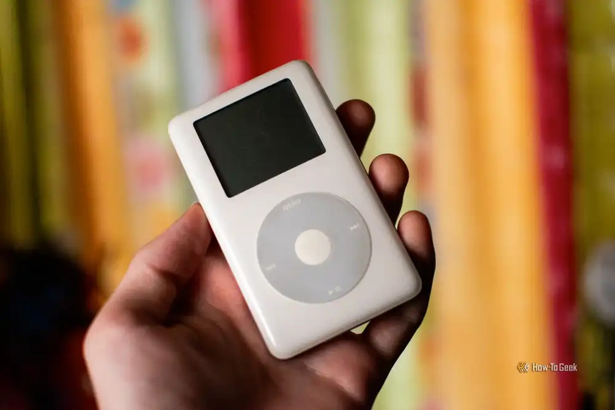 Hand holding an old click wheel Apple iPod.