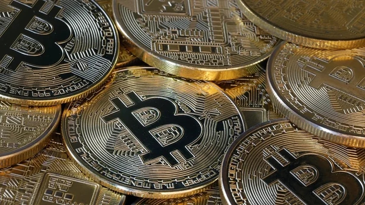 a pile of gold coins with the Bitcoin symbol on them