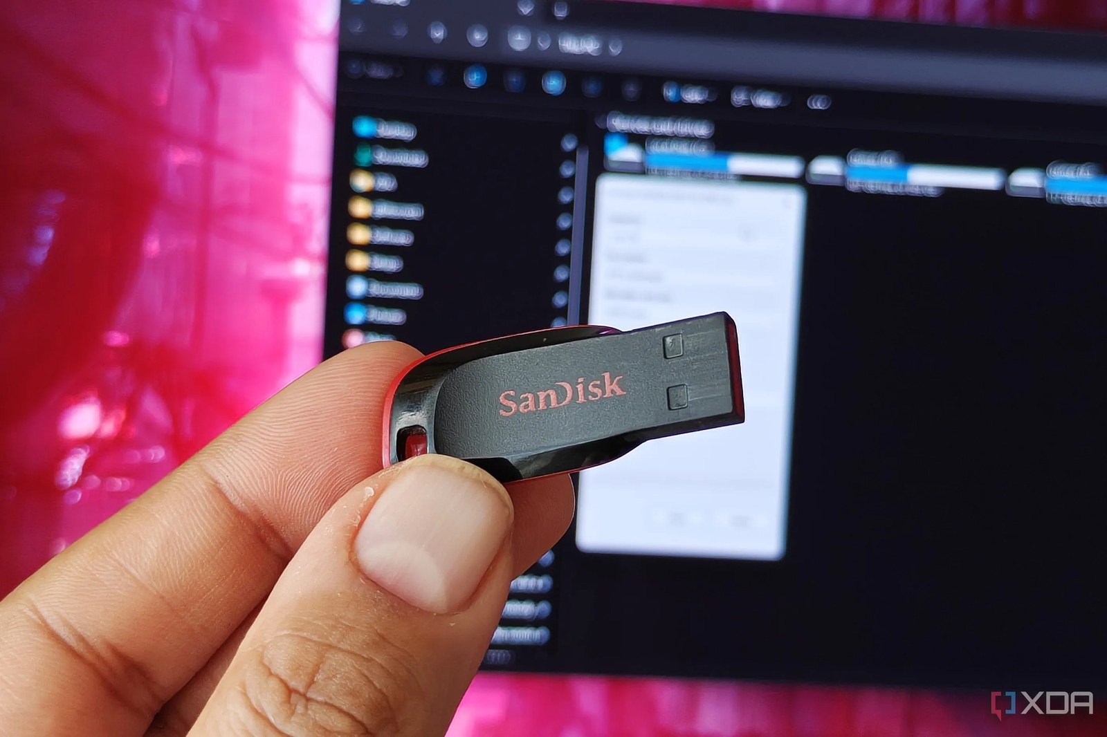 Bir monitörün önünde bir USB bellek tutan el