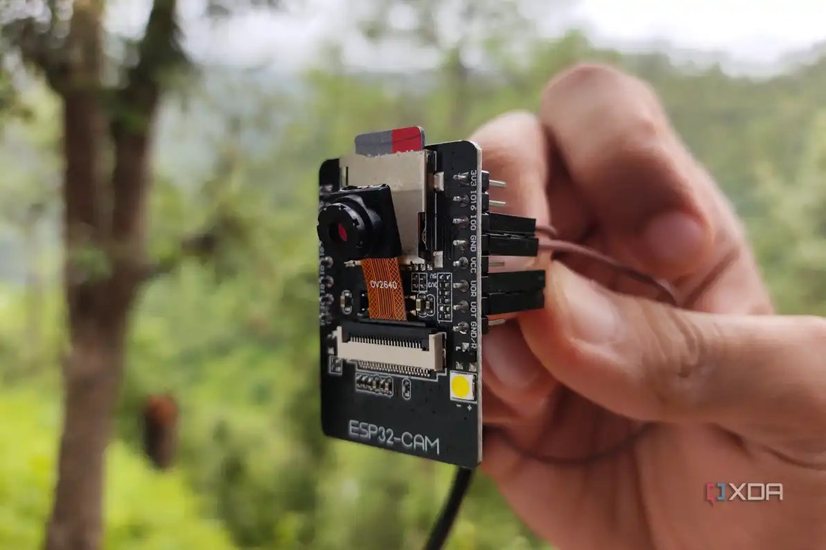 A person holding an ESP32-CAM board