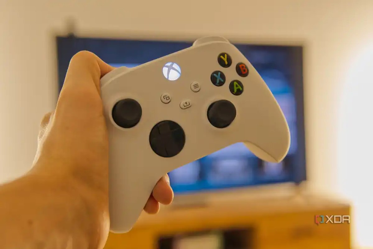 An Xbox Wireless Controller held in front of a TV