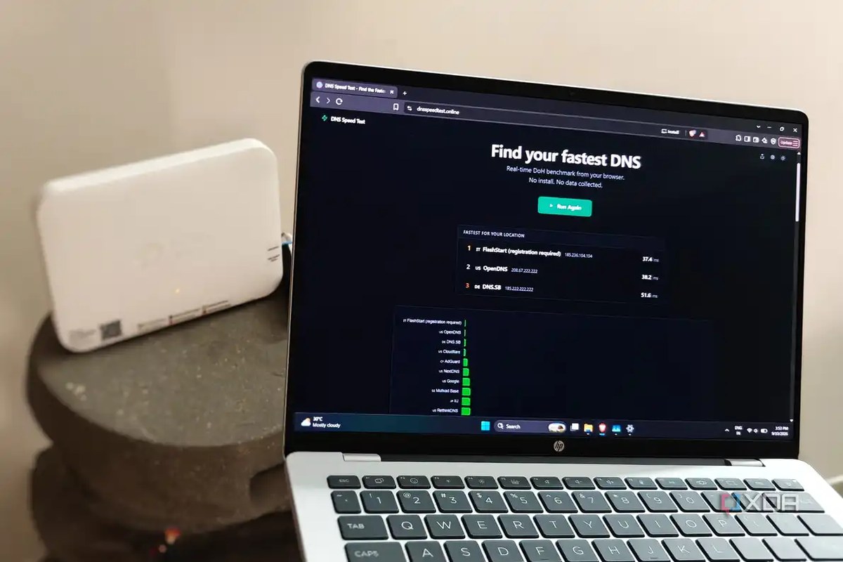 A laptop showing an online DNS test with a white router in the background